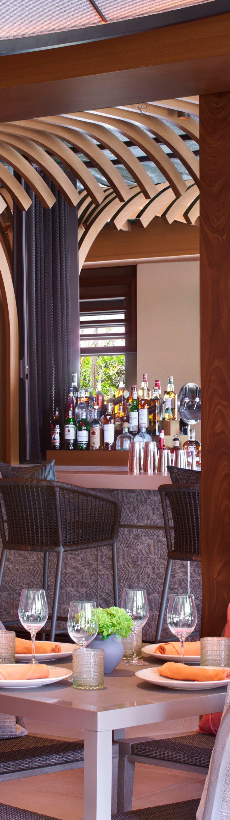 Two tables set for four with bar seating in backgr