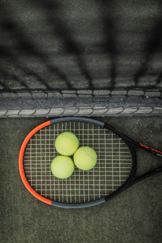 Tennis racket and three tennis balls 