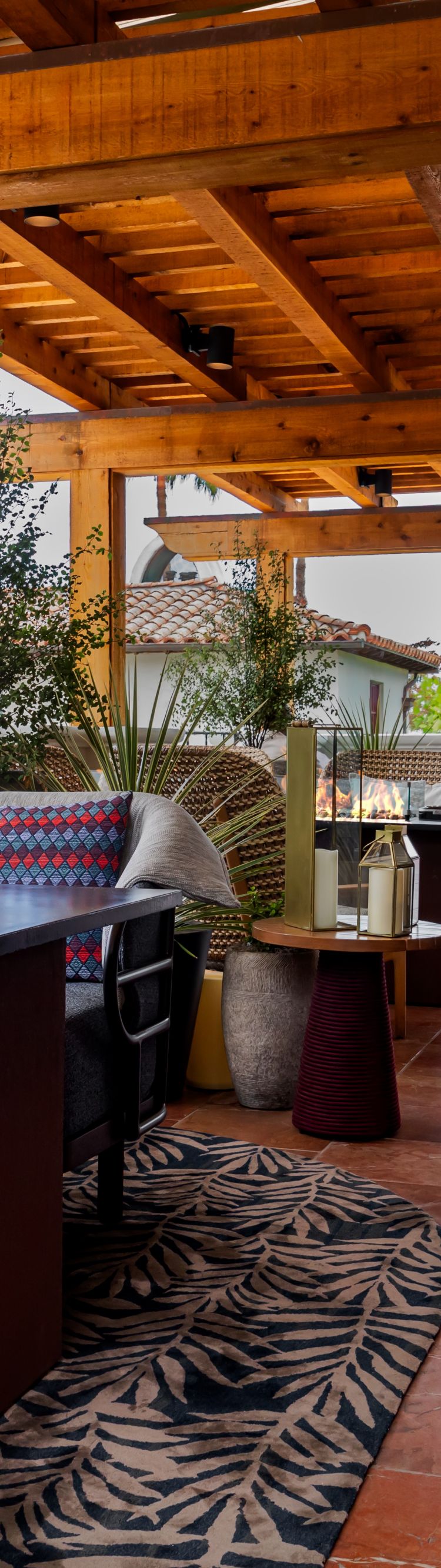 Outdoor lounge with fire pit and wood pergola.