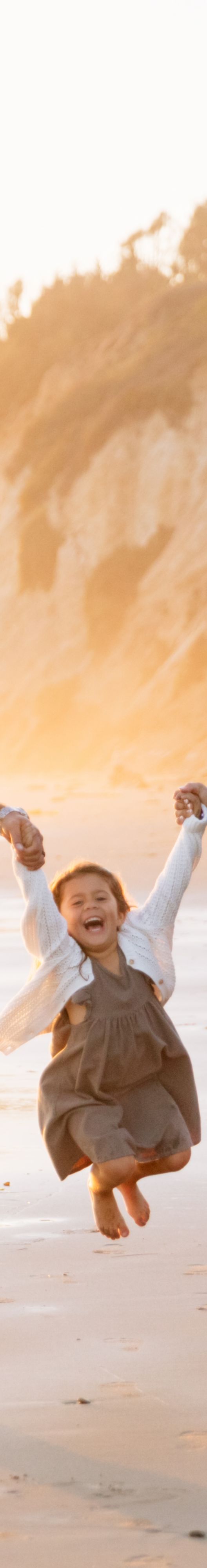 Family having a fun stroll on the beach with kids.