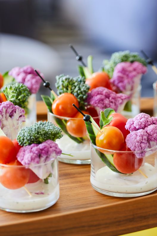 Crudites with vegetables in a small glass container with dipping sauce.