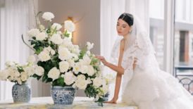 Bride in wedding dress admiring floral arrangement