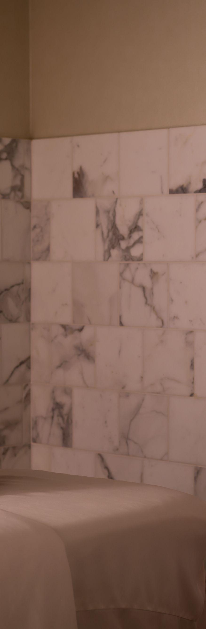 Woman wrapped in a sheet sitting on the edge of a massage table