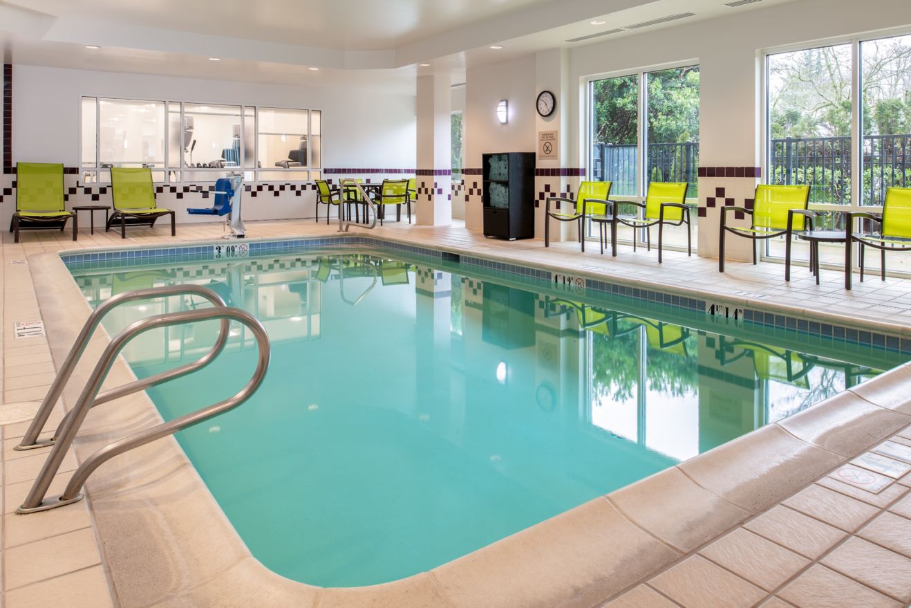 An indoor pool with seating and a table