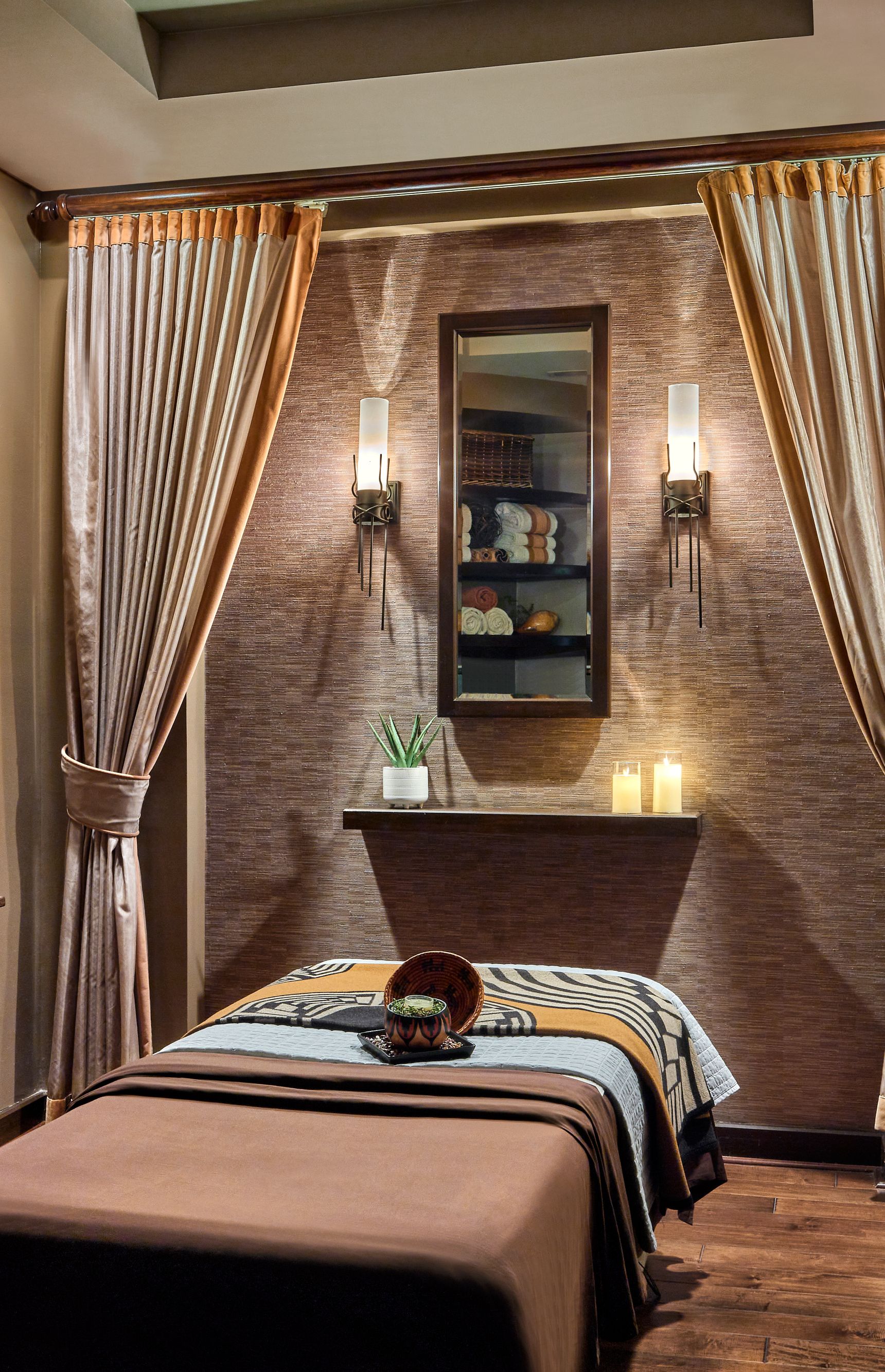 Spa treatment room with massage table and artwork on the wall.