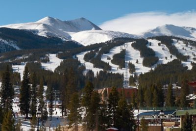 A landscape view of the snowy mountains with a ski lift in the distance
