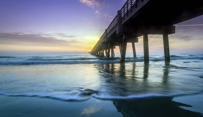 Pier in the ocean at sunset
