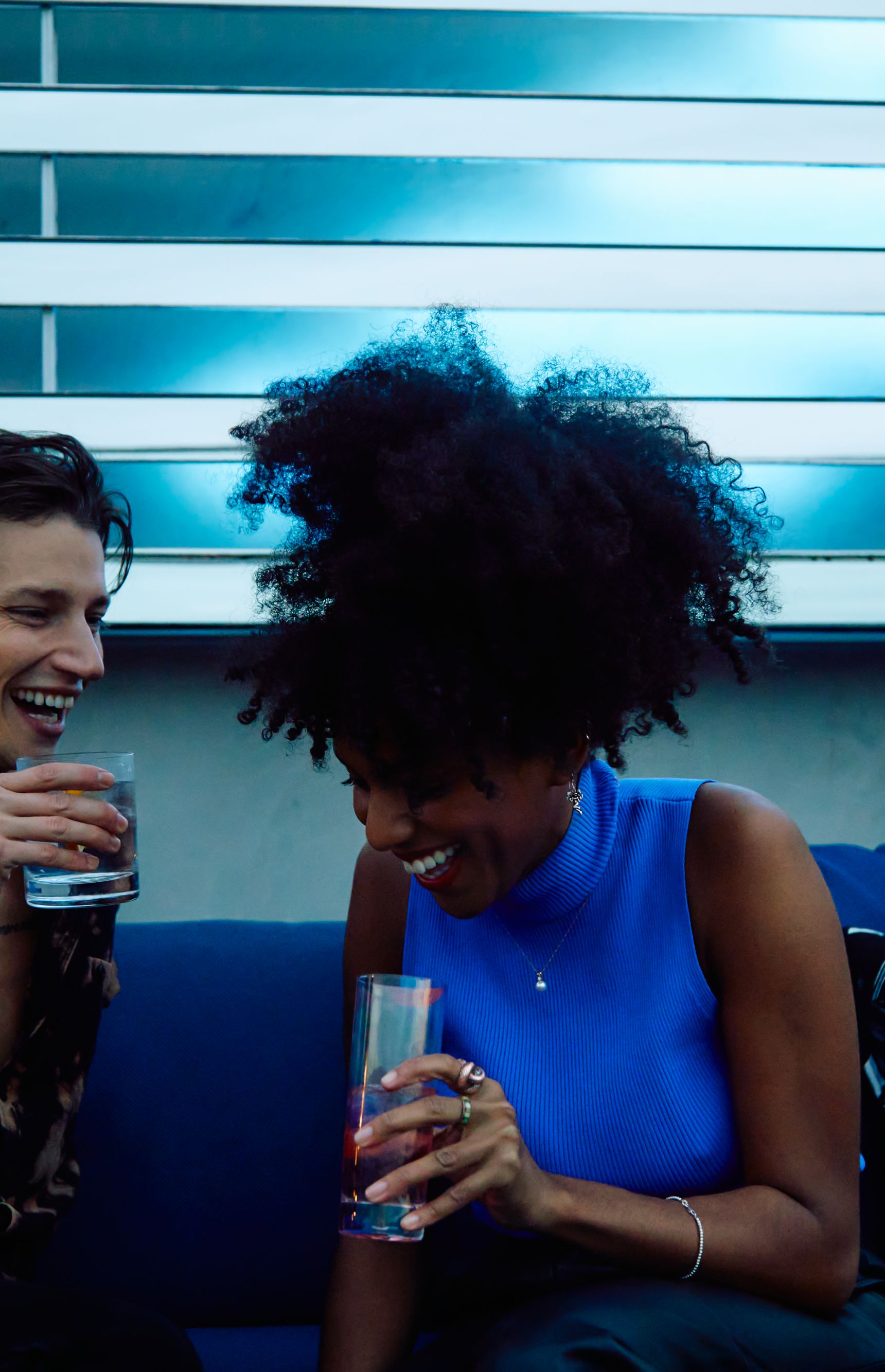 Man and woman drinking and laughing with cocktails