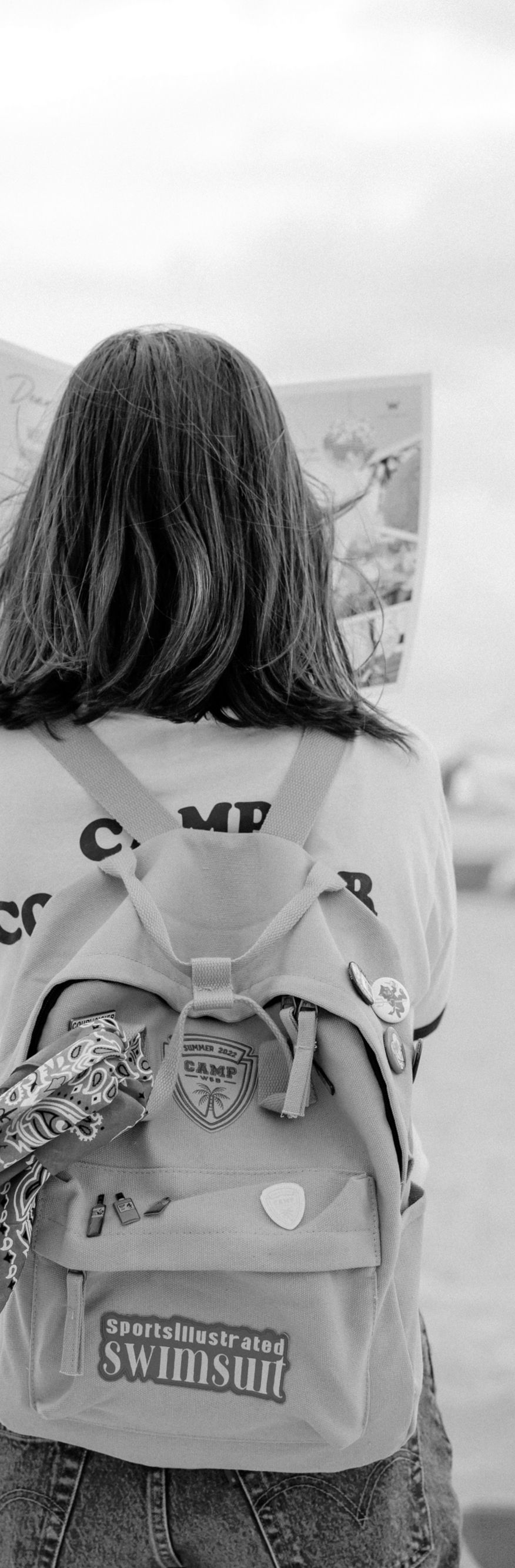 A person standing on a beach holding up a map.
