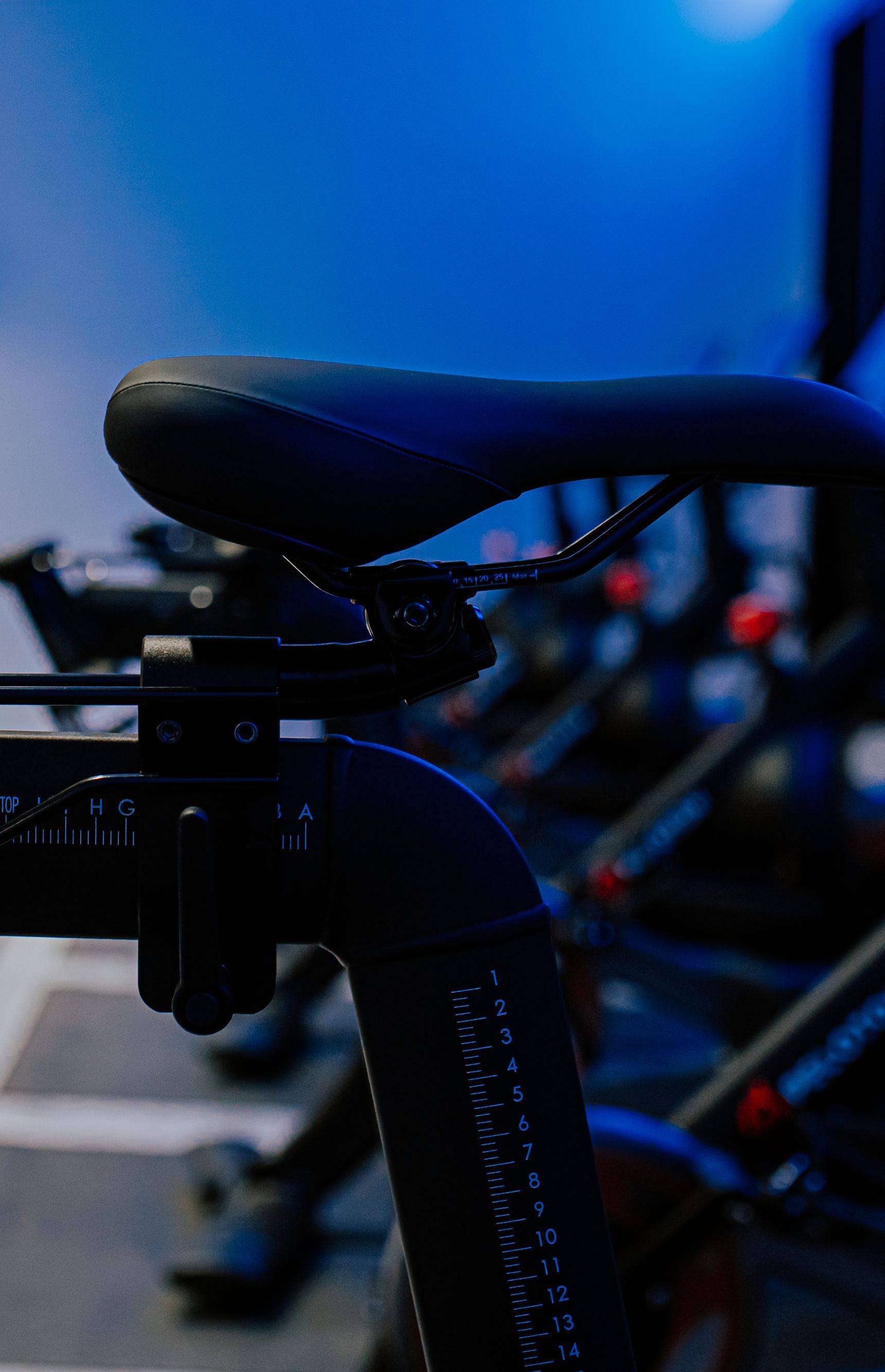 Peloton bikes in a row with hand weights attached to the back of the bikes.
