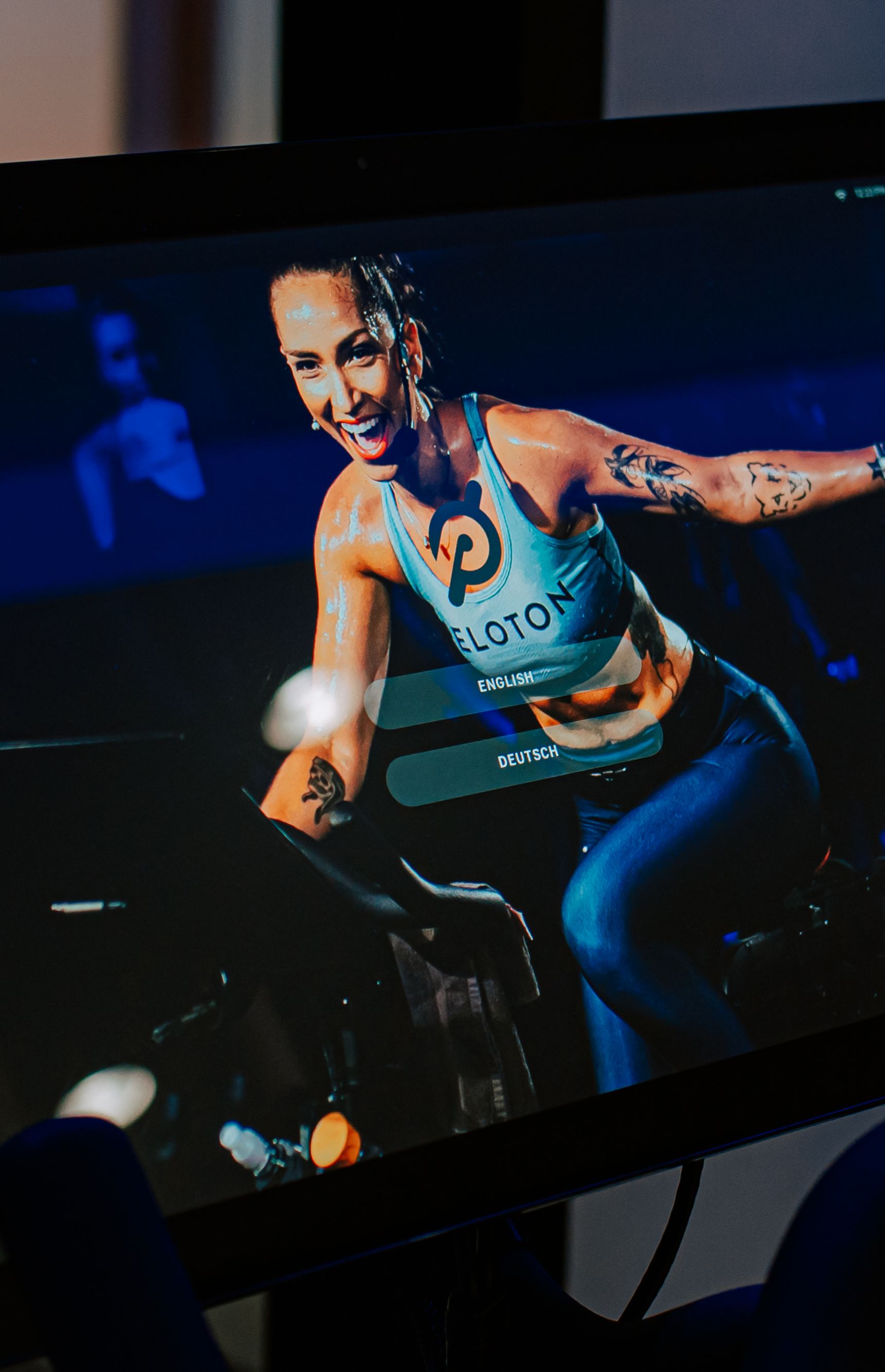 The screen of a peloton bike showing an instructor working out.