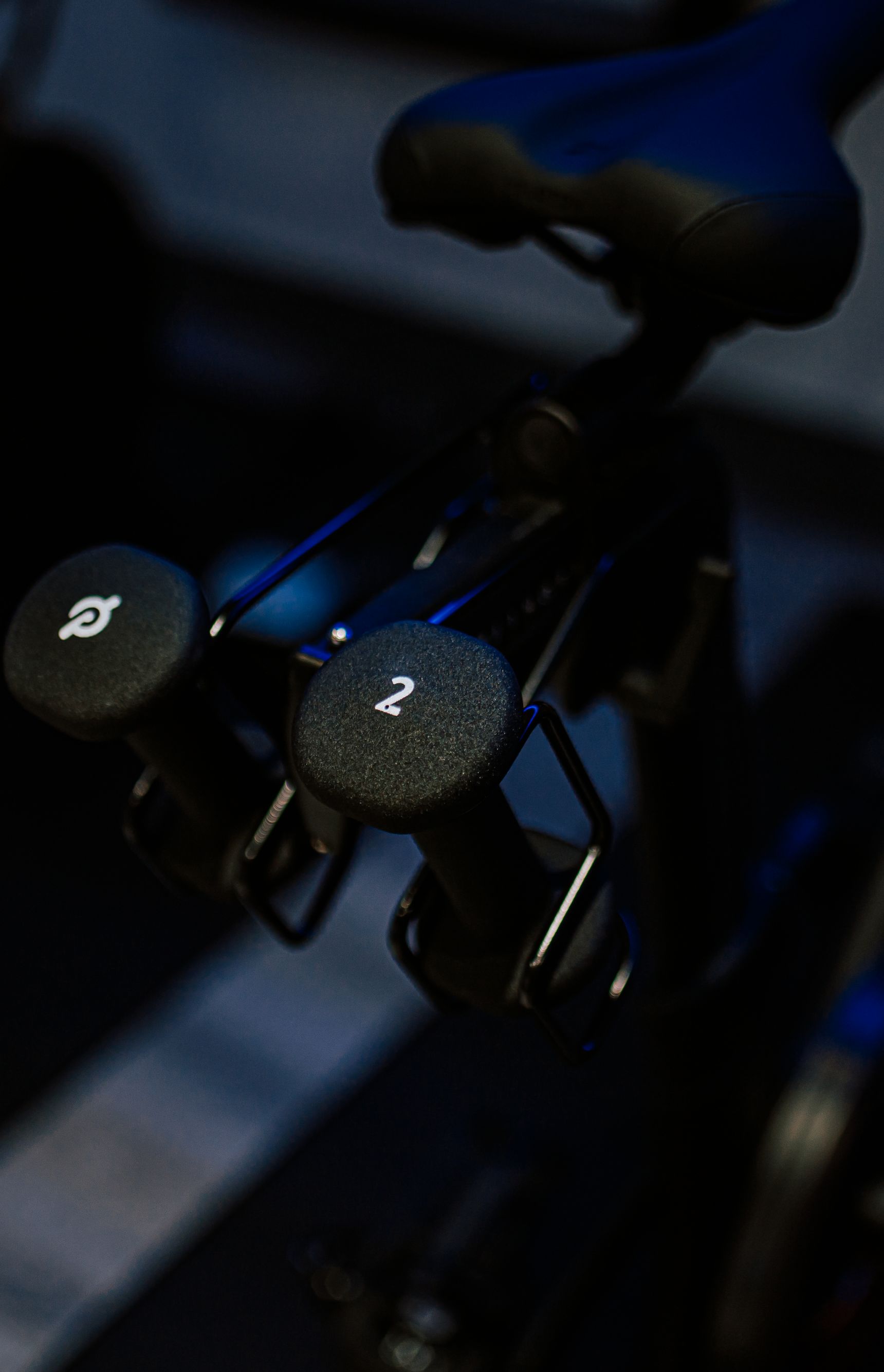 The seat of a peloton bike with weights attached to the bike of the bike.