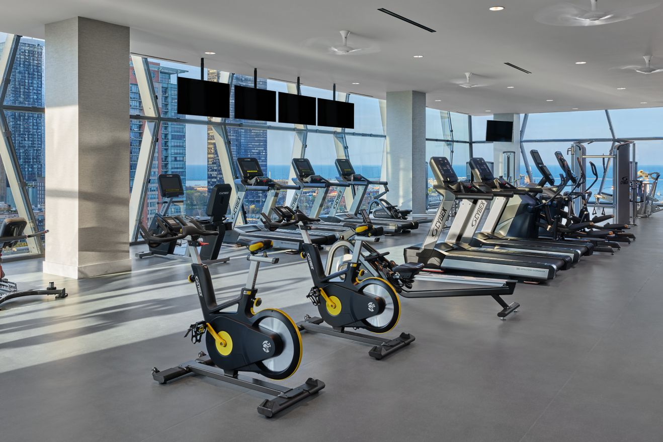 Gym with bikes treadmills tvs and a view