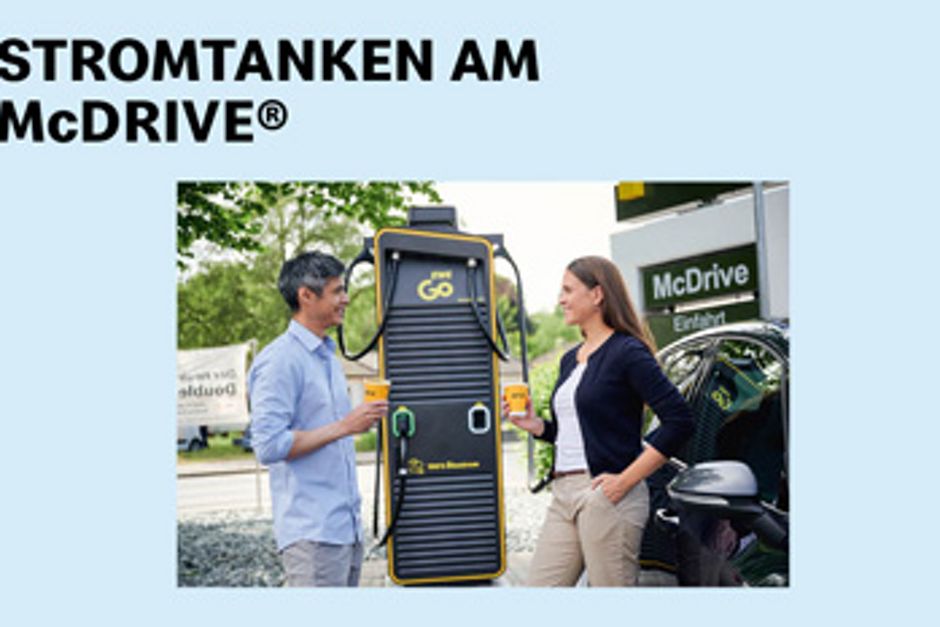 Zwei Personen stehen an einer Strom-Tankstelle von EWE bei McDonald's