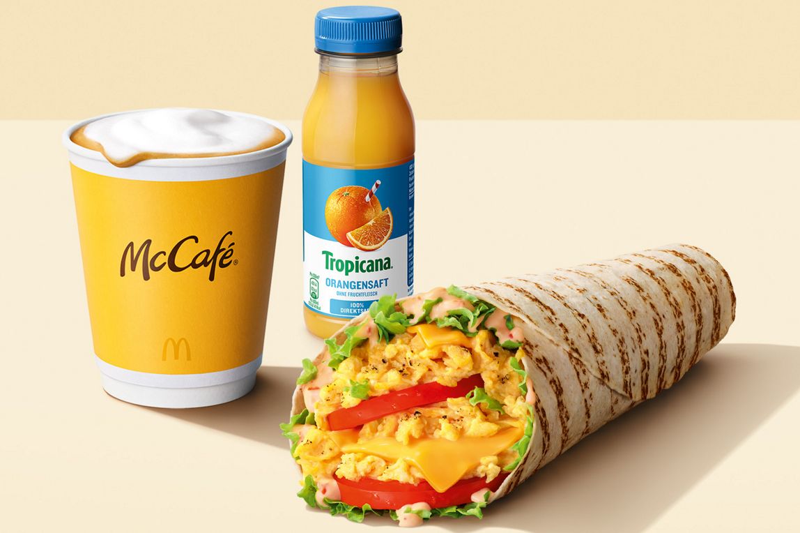 Das Bild zeigt einen Orangensaft, Cappuccino und McWrap® Cheese.