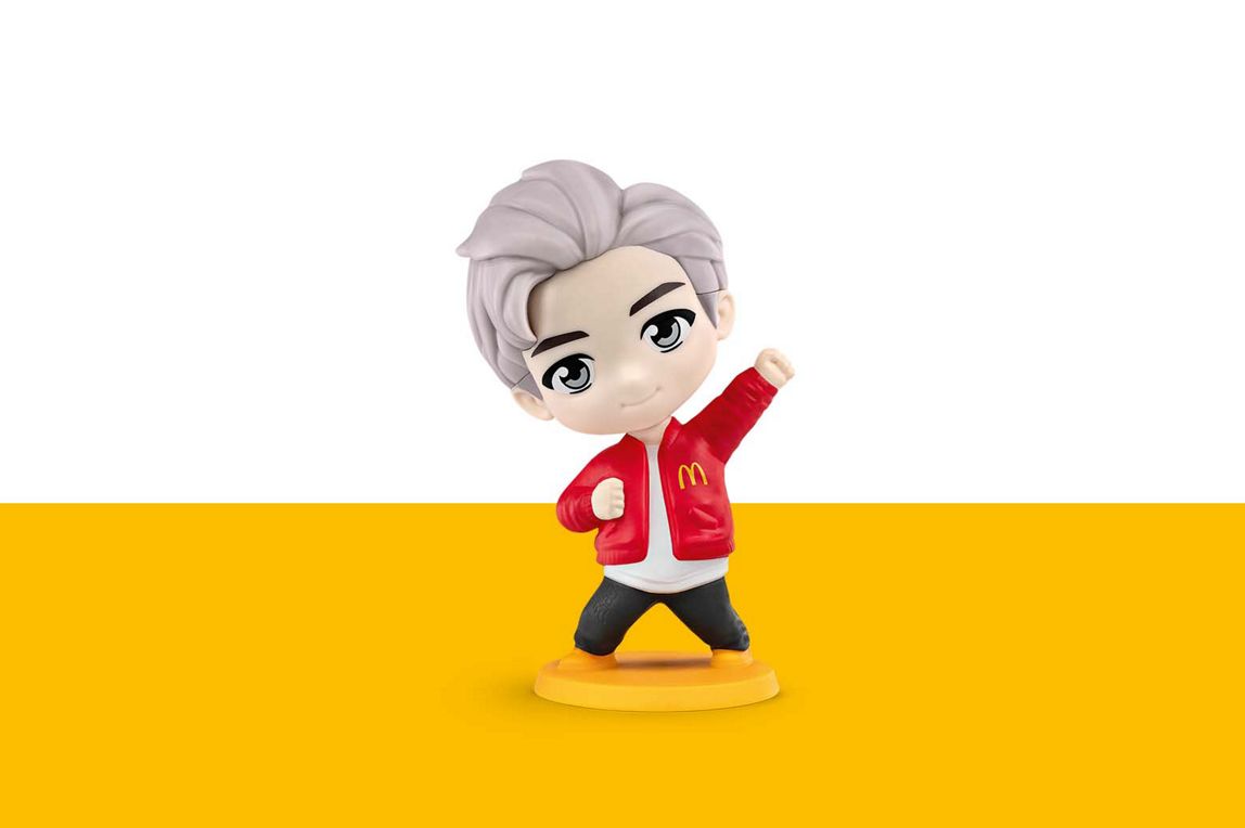 RM hat weiße Haare und trägt eine rote Collegejacke mit einem goldenem M auf der Brust.