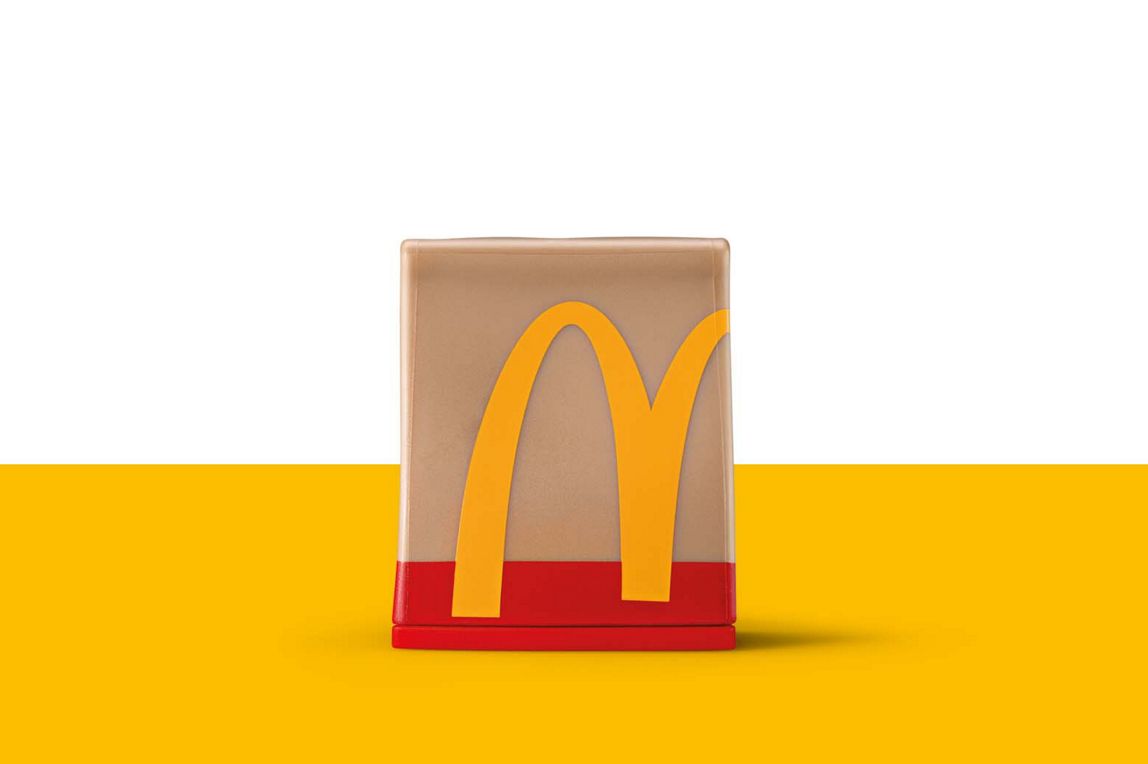 Eine braune McDonald‘s Take-Away Tüte mit Arches und rotem Boden goldenenals Miniatur-Spielzeug.