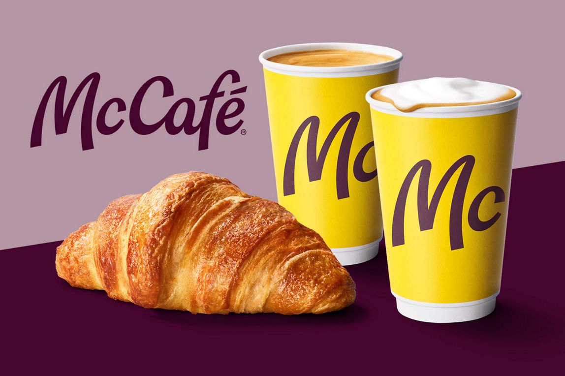 McCafé. Wir sehen Kaffee-Spezialitäten und ein Croissant.