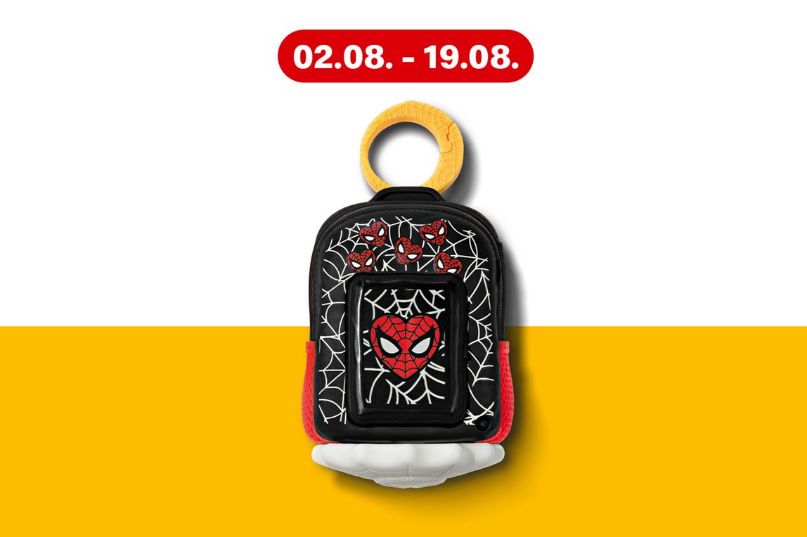 Produktfoto eines schwarzen Spider-Man-Kinderrucksacks mit rotem Herz in Spiderman-masken Optik präsentiert auf einem gelben Hintergrundband.
