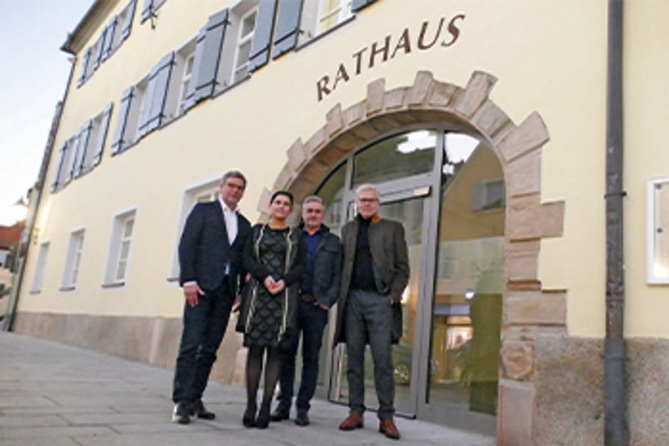 Vier Personen vor einem Rathaus