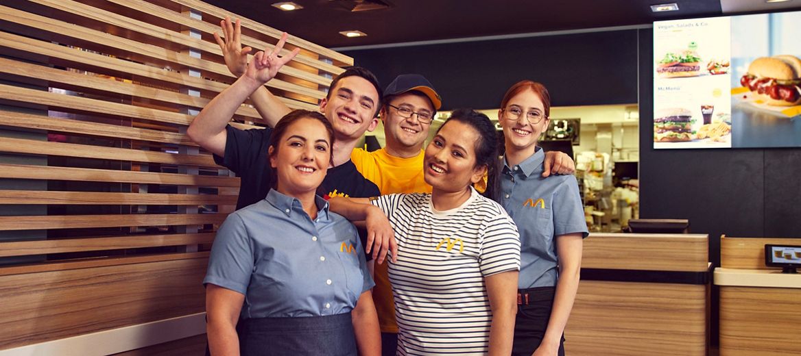 Crew-Mitglieder verschiedenen Alters und Nationalität lächeln in die Kamera