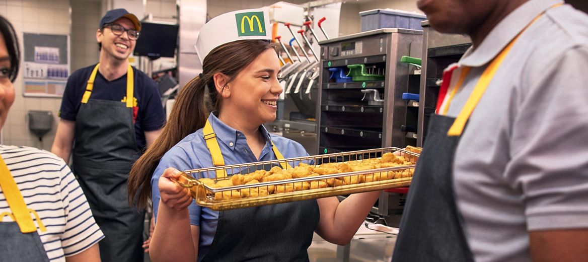 Mitarbeiterin bereitet Chicken Nuggets zu