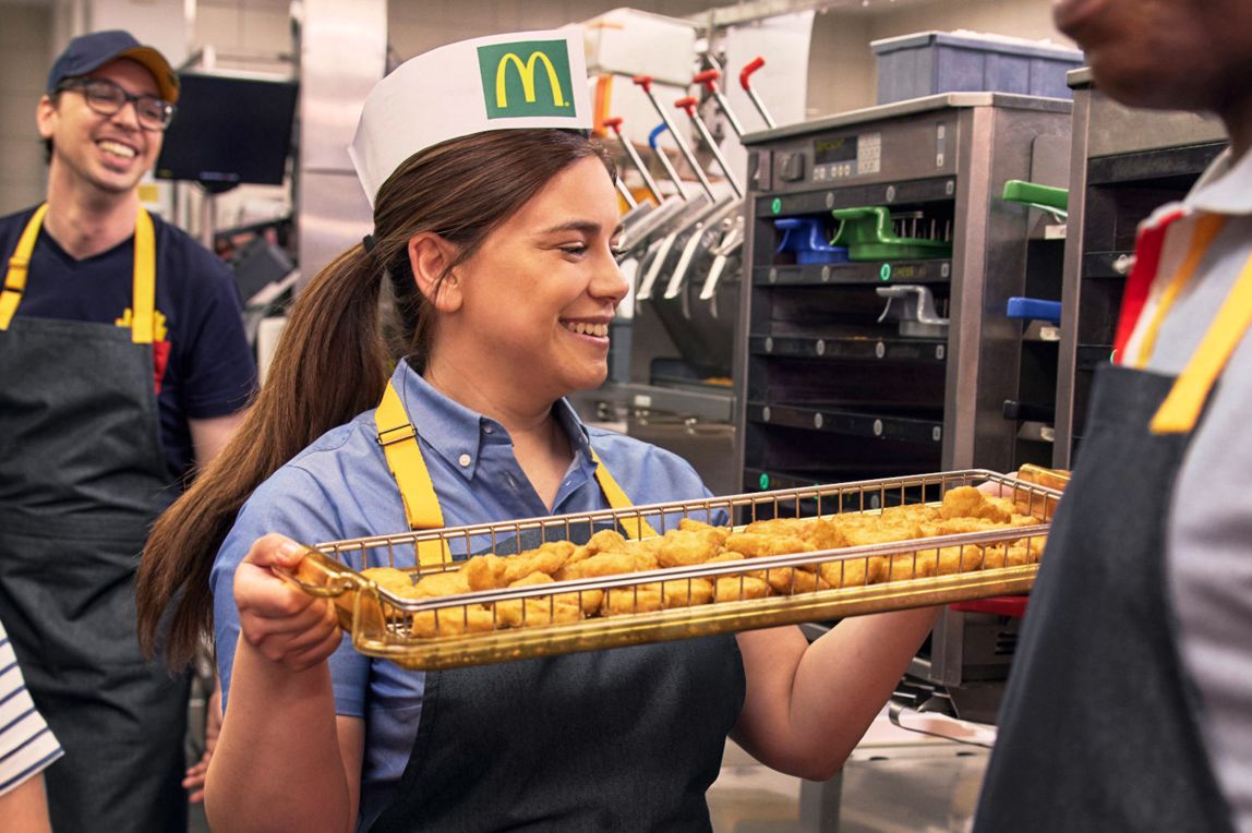 Mitarbeiterin bereitet Chicken Nuggets zu