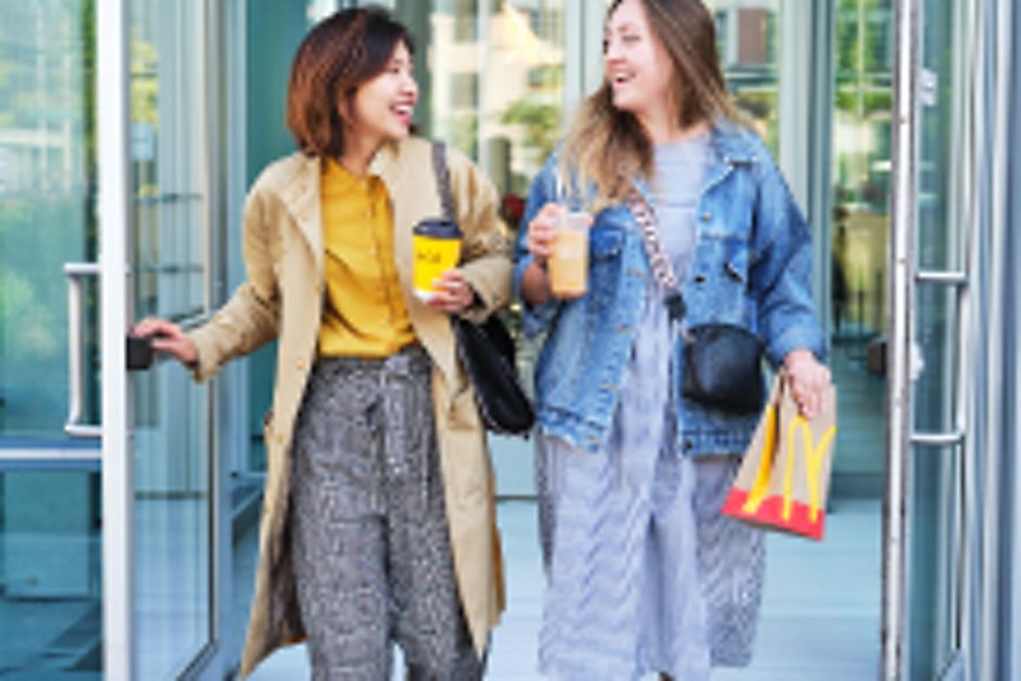 Two women leaving a McDonald's location holding food and drinks