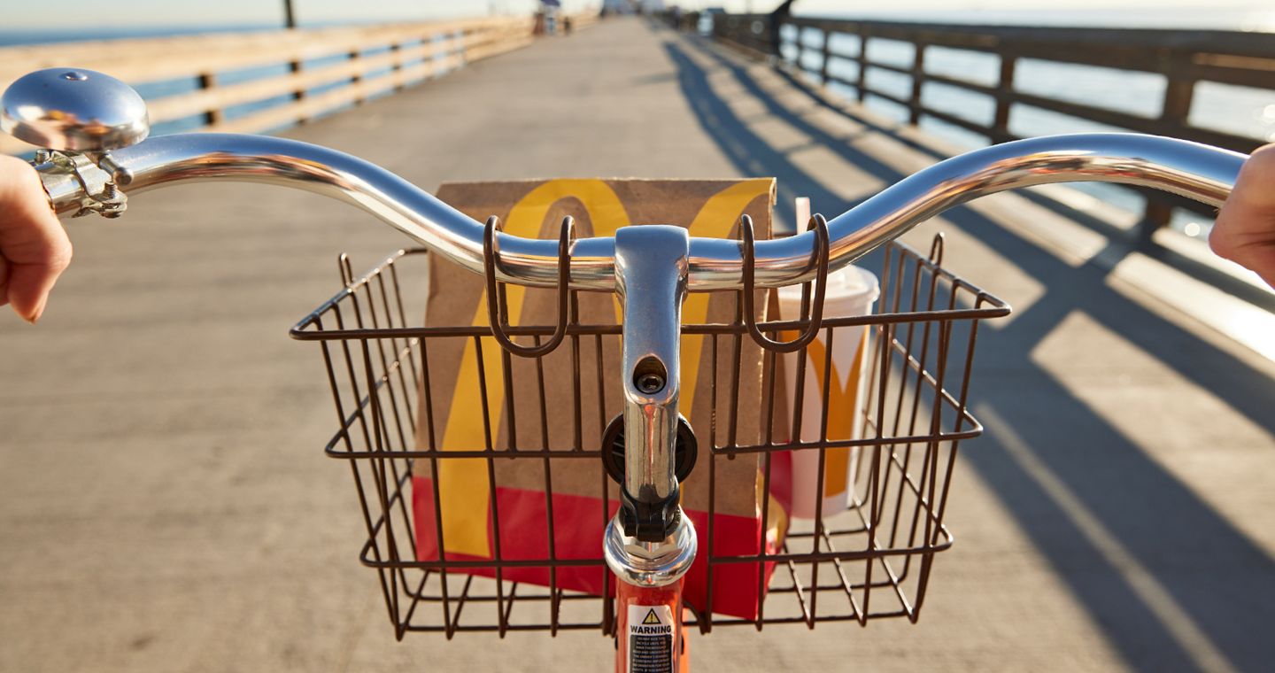 POV of bike riding with McDonald's bag in front rack