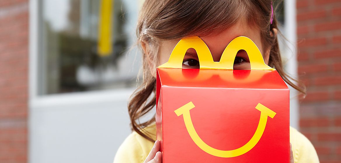 Happy Meal package in front of girl's face