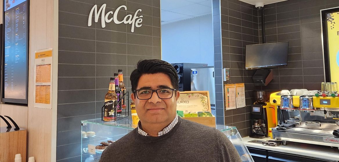 en McD ansatt står forran McCafe