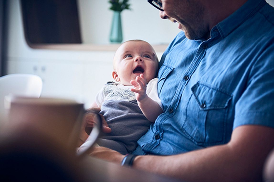 Ein Baby liegt in den Armen einer Person