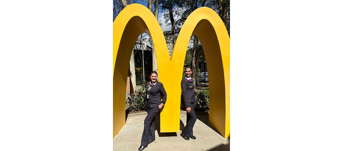 McDonald’s Latin America employees posing in front of a McDonald’s “M” statue 