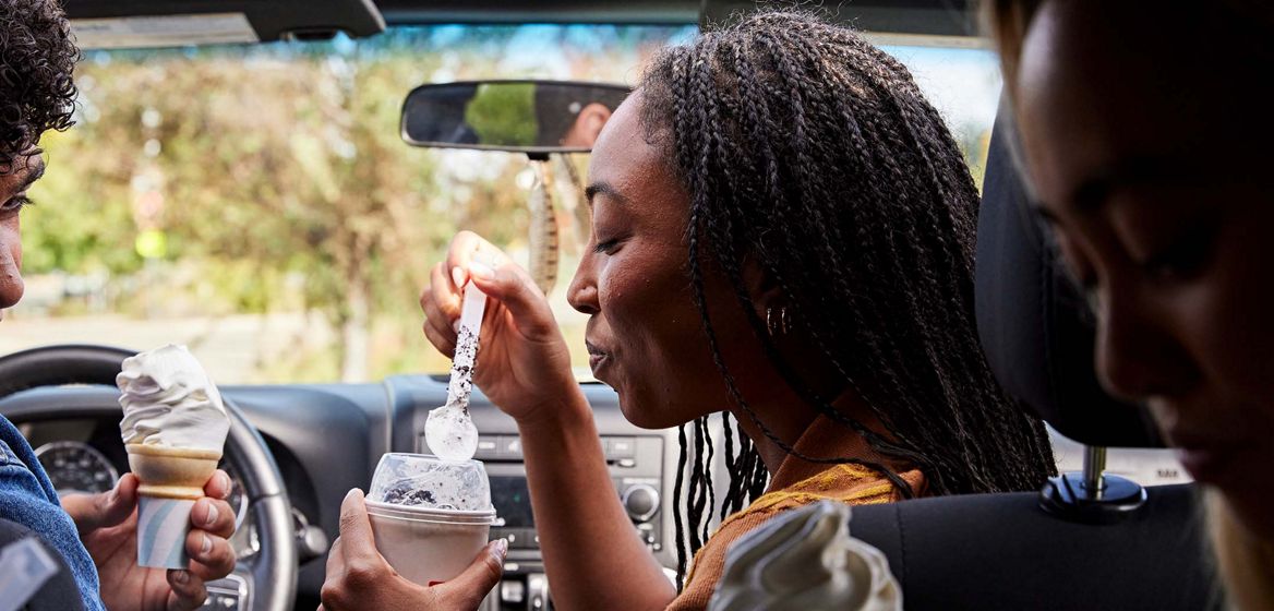 woman eating a McFlurry inside a car 