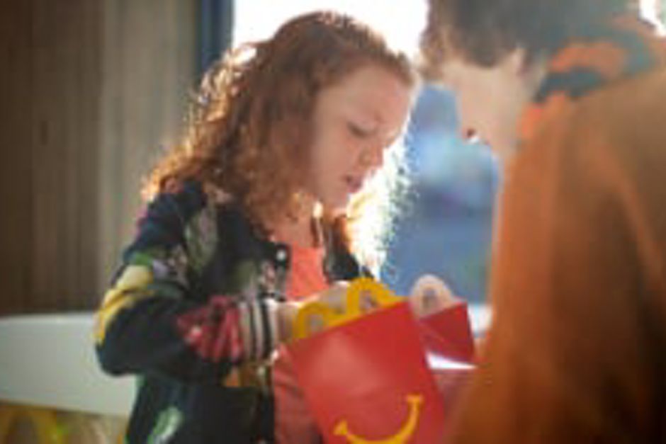 Father holding a Happy Meal box for daughter to open