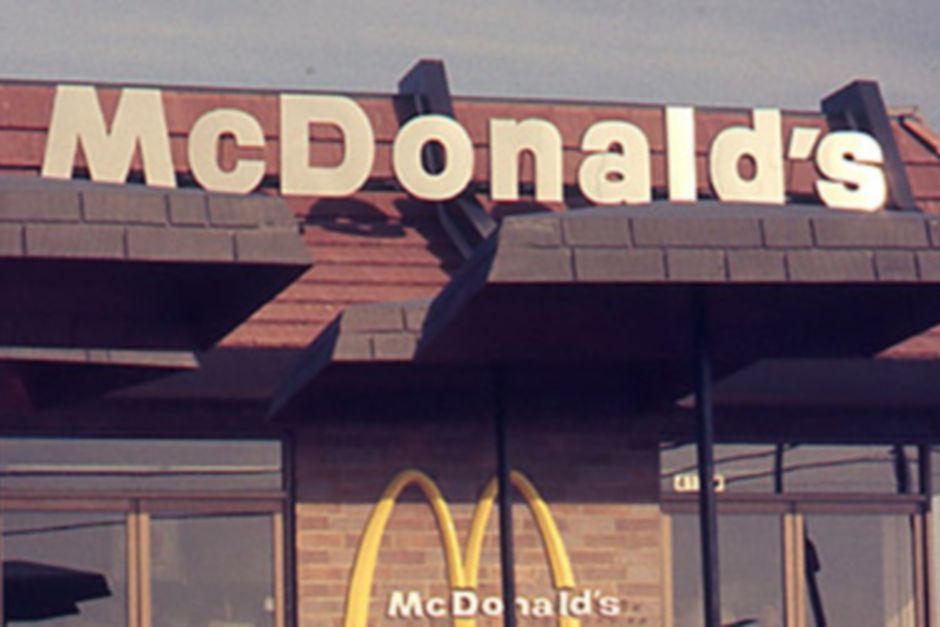 A modern exterior of a McDonald's storefront with arches symbol