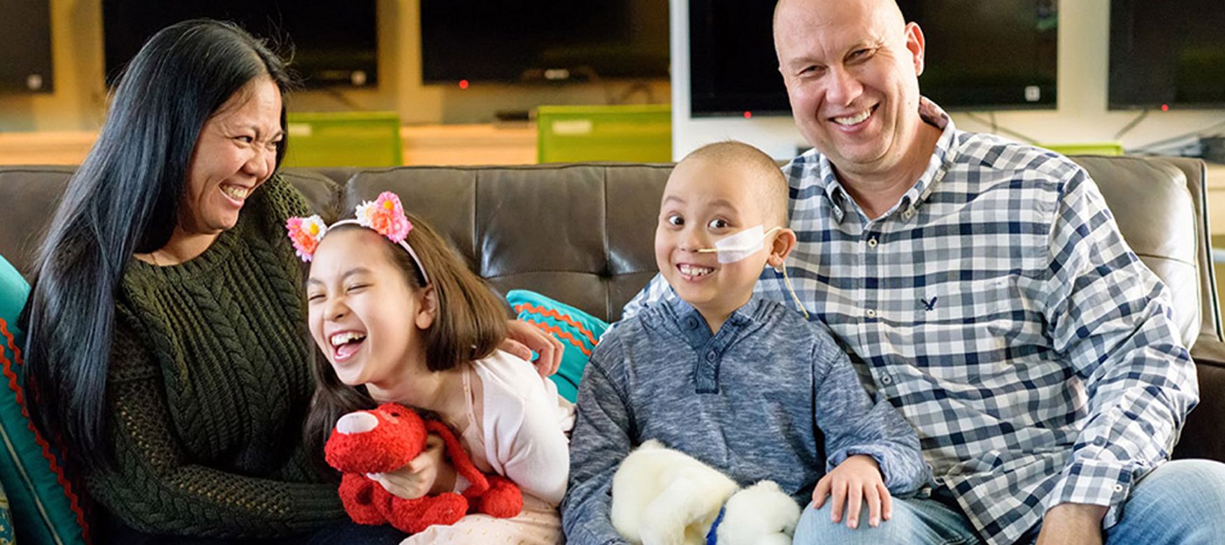 The Czyz RMHC family of four laughing together on a couch