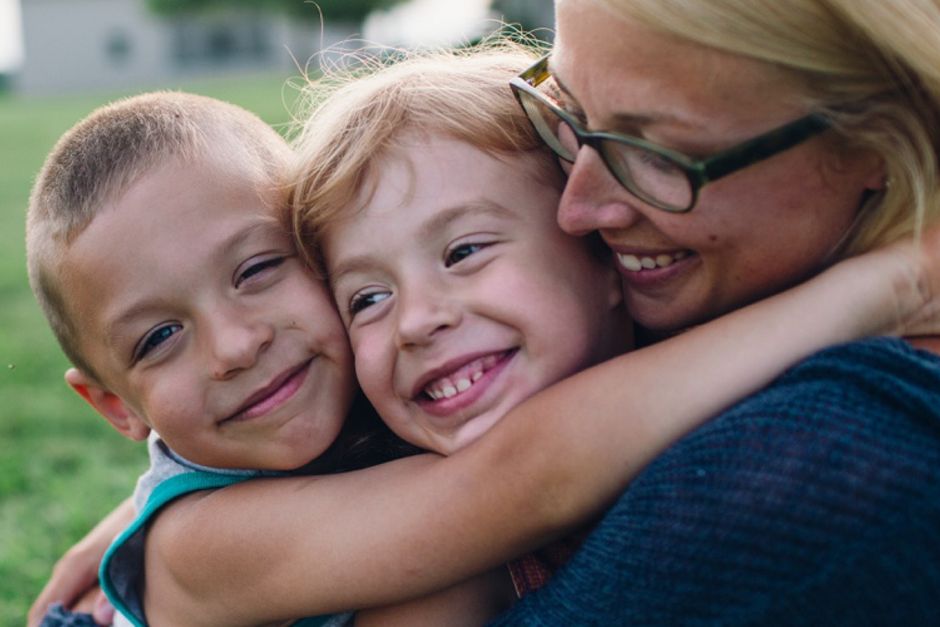 Mother hugging daughter and son