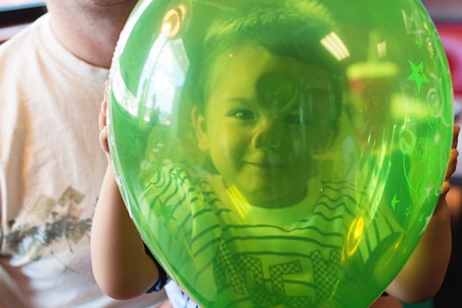 Baby smiling through balloon