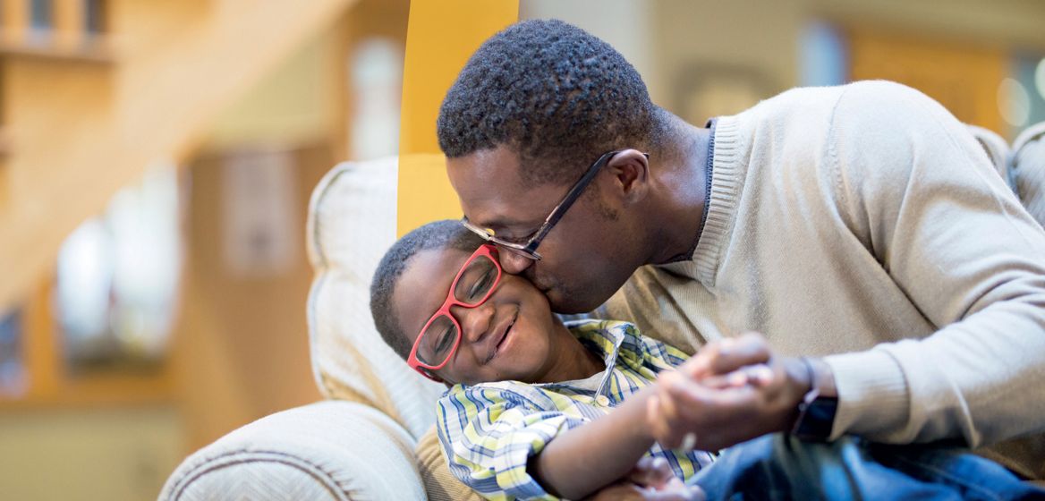 A man kissing and embracing a child