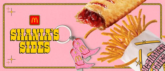 The words “All Dressed Up with Shania Twain” on a pink, country-style background” next to All Dressed McShaker Fries, a Strawberry Pie, and a pink cowboy boot keychain.