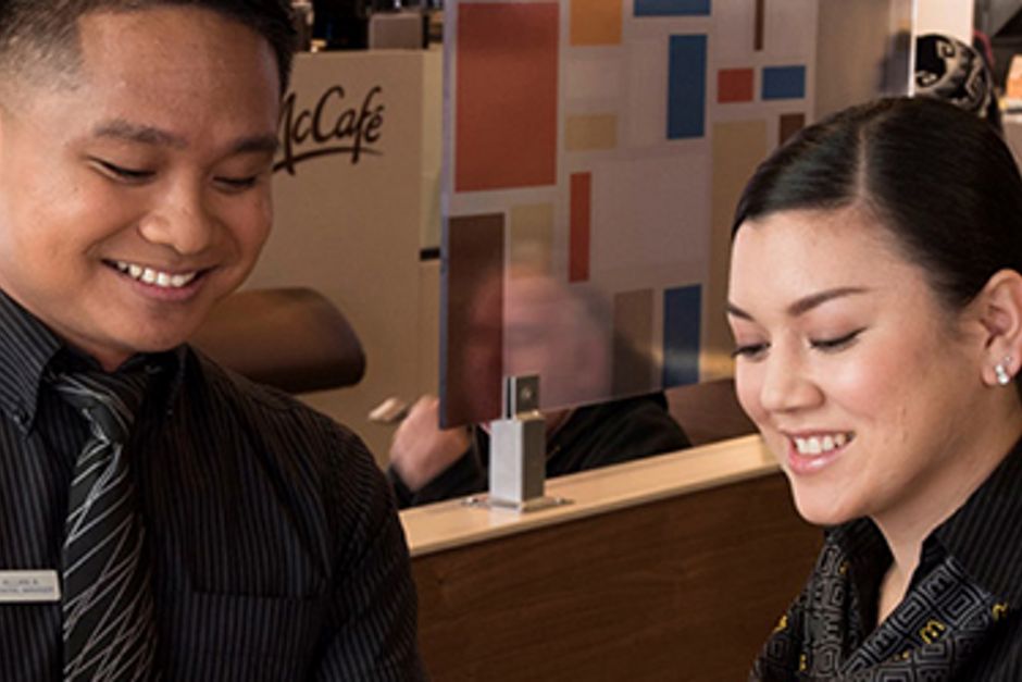 McDonald's staff members smiling while reviewing a document