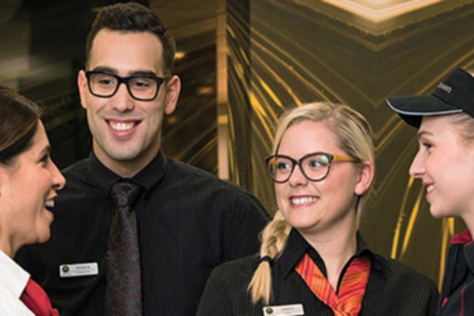 Four McDonald's staff members smiling and chatting