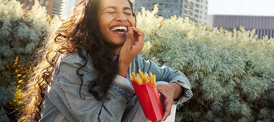 A woman enjoying eating fries
