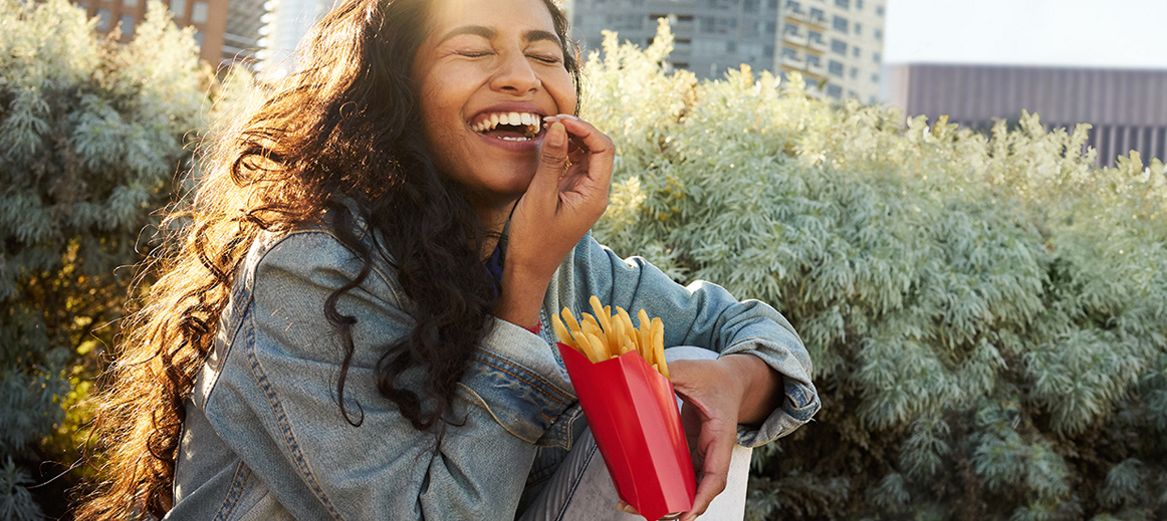 A woman enjoying eating fries