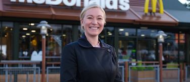 Franchisee smiling outside her restaurant.