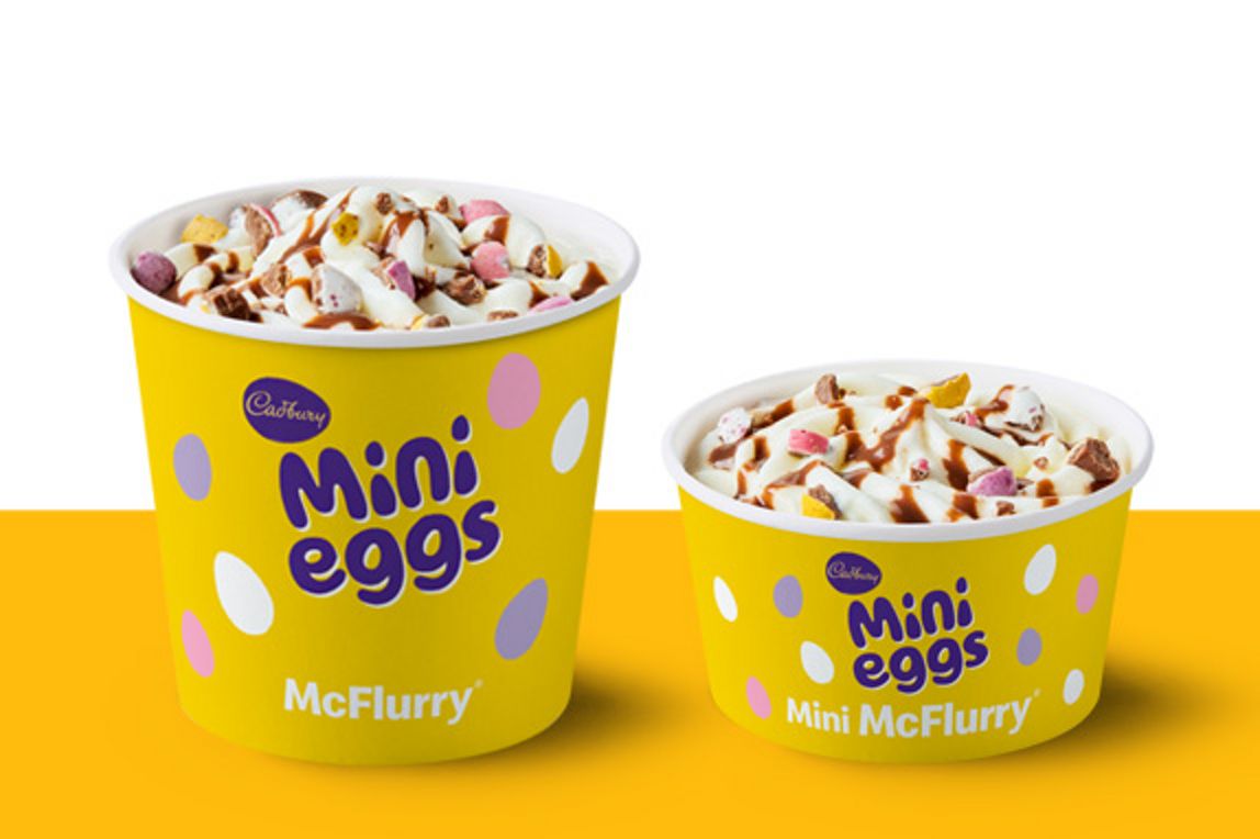 Regular and mini Cadbury Mini Eggs McFlurry cups on a yellow and white background with chocolate pieces on top.