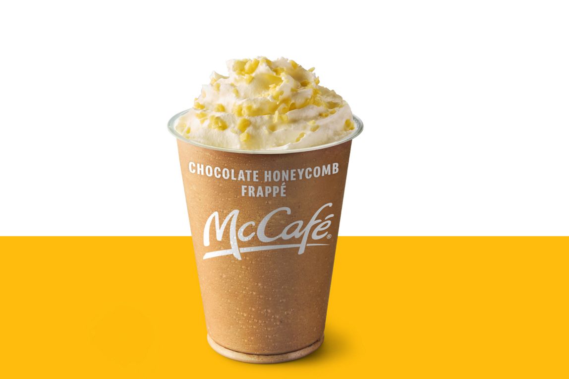 Chocolate Honeycomb Frappe topped with a swirl of whipped cream and honeycomb pieces set against a yellow and white background