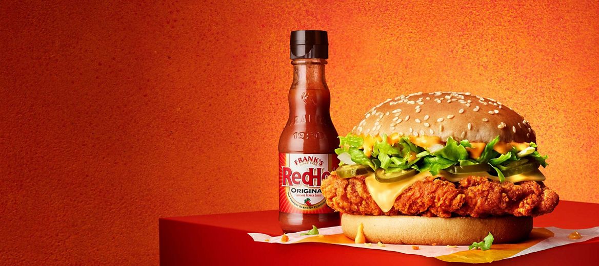 McSpicy Burger with the Franks Extra Hot Sauce on a fiery, red-coloured background.