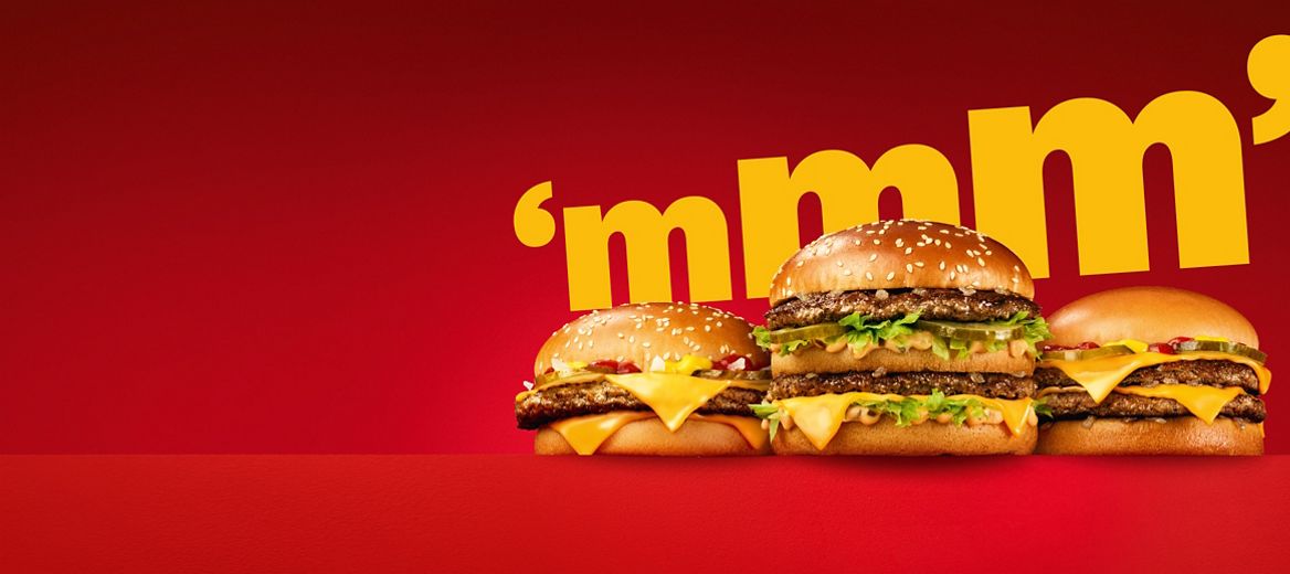 Three burgers on a red plinth and a red background.